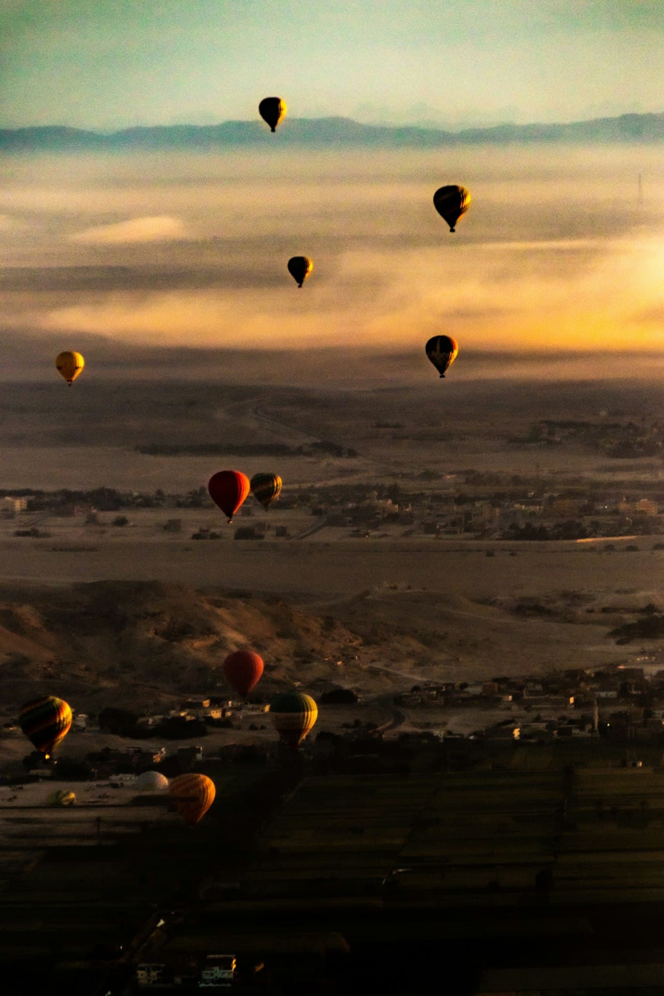 Hot air balloons drifting over the west bank of Luxor at first light