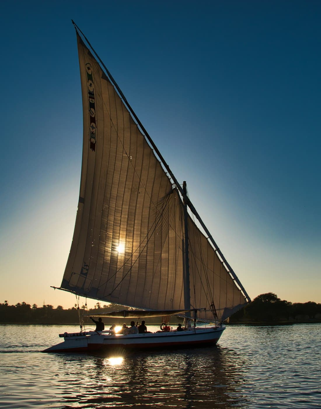 A felucca under sail on the Nile as the sun goes down